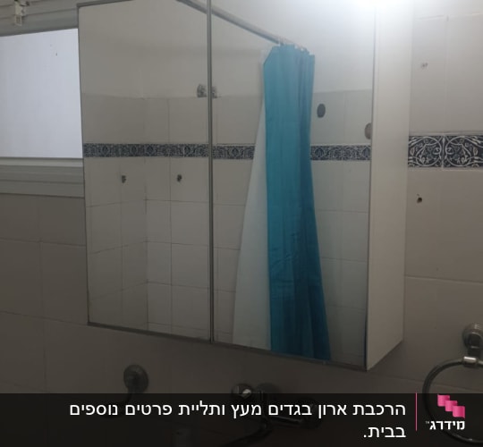 חדר אמבטיה עם מראה וארון קיר